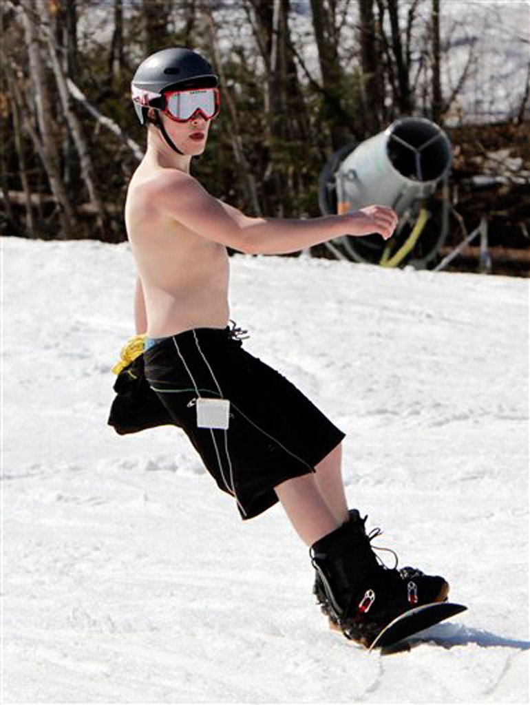 Ben Landry, 15, from Prince Edward Island, Canada, enjoys the warm sun while snowboarding in unusual weather for this time of year at Sunday River in Newry, Maine, on Wednesday, March 21, 2012. (AP Photo/Pat Wellenbach)