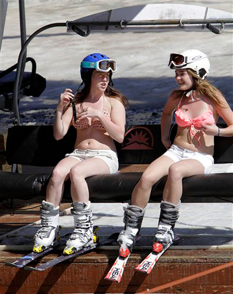 Sydney Warren, left, and Allie Ward, both 15 and from Prince Edward Island, Canada, enjoy the warm sun as they ride the chair lift while skiing in unusual weather for this time of year at Sunday River in Newry, Maine, on Wednesday, March 21, 2012. (AP Photo/Pat Wellenbach)