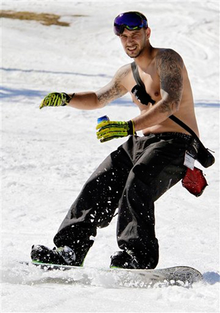 Jonathan DaRosa, of Taunton, MA., enjoys the warm sun while snowboarding in unusual weather for this time of year at Sunday River in Newry, Maine, on Wednesday, March 21, 2012. (AP Photo/Pat Wellenbach)