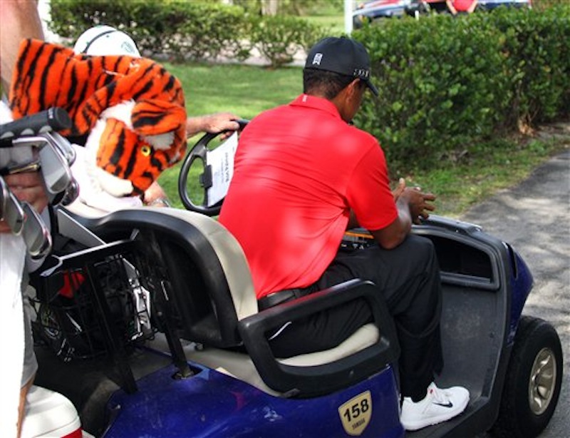 Tiger Woods is driven away in a cart after hitting off the 12th tee during the final round of the Cadillac Championship golf tournament on Sunday, March 11, 2012, in Doral, Fla. Woods withdrew from the tournament. (AP Photo/Wilfredo Lee)