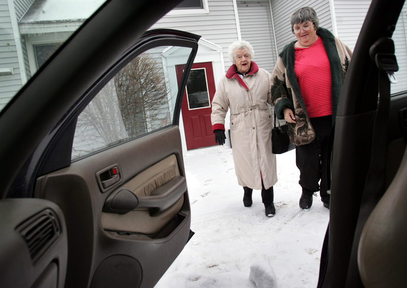 A woman who traded her car to the Independent Transportation Network in exchange for rides is escorted to an ITN vehicle in Portland. AARP can help adult children figure out how to discuss road safety with their parents.