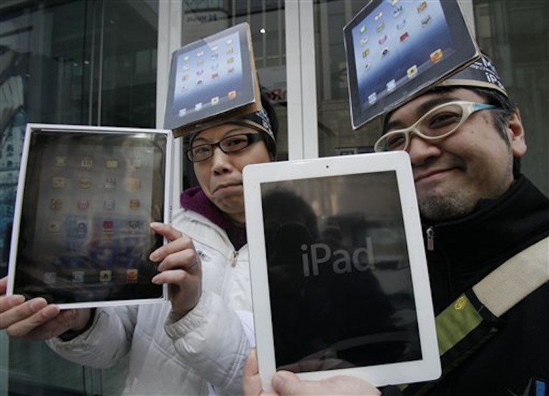 Japanese Ryota Musha, 41, right, and Hisanori Kogure, 31, show off new iPad tablet computers they purchased in Tokyo today. Sales of the third version of Apple's iPad began Friday morning in the U.S. and across the world. (AP Photo/Koji Sasahara)