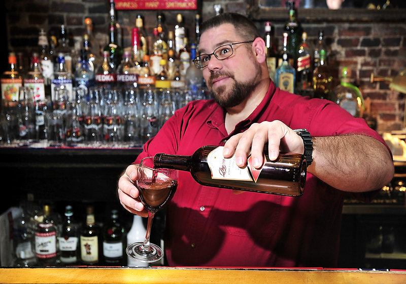 Jeff Dalbec, who has tended bar at Brian Boru in Portland for 19 years, pours a glass of red wine.