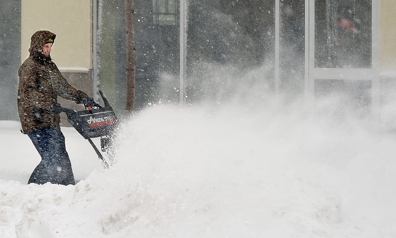Jake Hall, working for Smith & Sons Excavation, clears snow from sidewalks around Turner Barker Insurance in the Bayside area of Portland on Thursday.