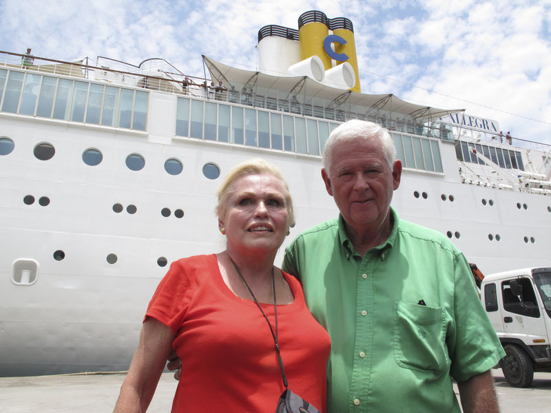 Costa Allegra passengers Gordon Bradwell and his wife, Eleanor, of Athens, Ga., pose in front of the cruise ship in Victoria’s harbor, Seychelles Islands, Thursday.