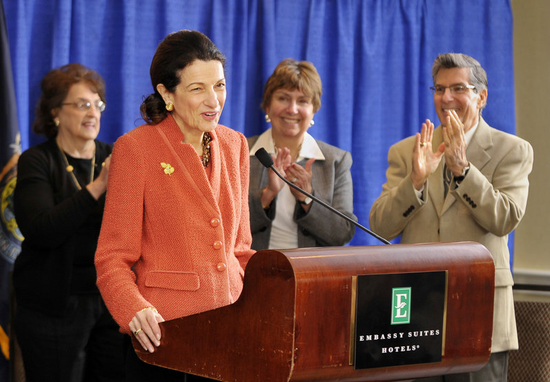 Sen. Olympia Snowe gets a standing ovation from family and friends Friday as she begins a news conference at the Embassy Suites hotel near the Portland International Jetport to talk about her decision not to run for another term.