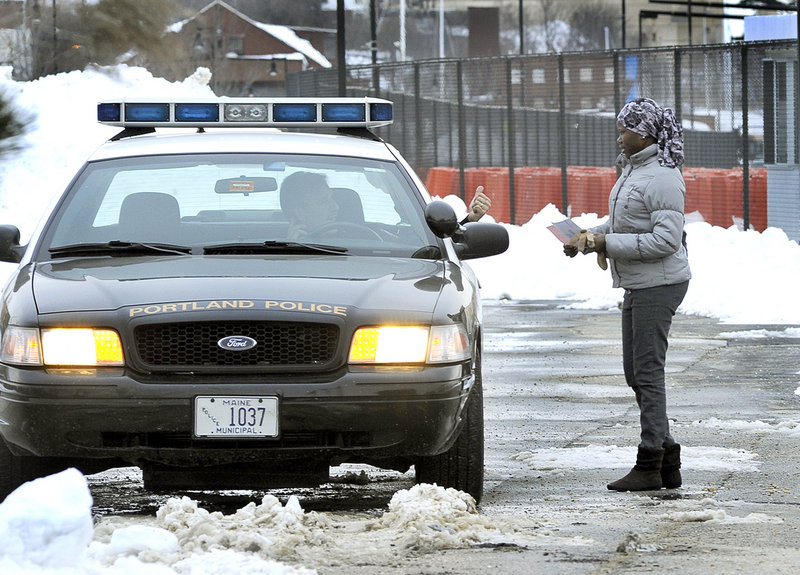 Marwa Abdalla of Portland shows a Portland police officer proof of payment to get her car out of impoundment at the Maine State Pier lot Friday after it was towed Thursday night during Portland’s parking ban.