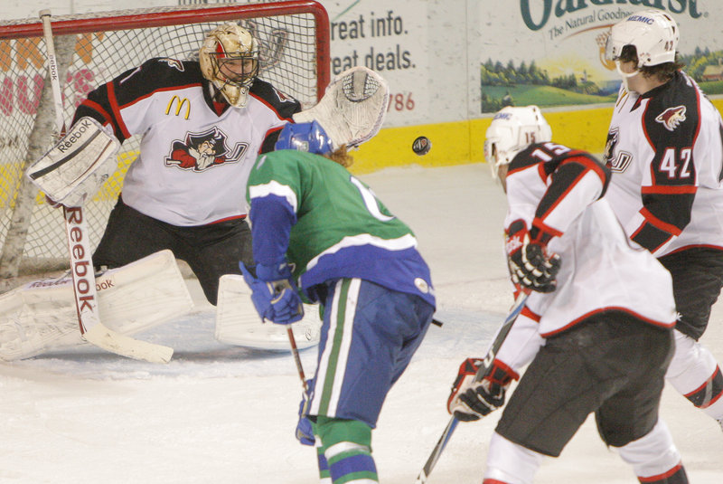 Pirates goalie Justin Pogge flashes out his glove to make a save on a shot by Kris Newbury of the Connecticut Whale. Pogge finished with 26 saves, and Portland got two third-period goals for a 3-2 victory.