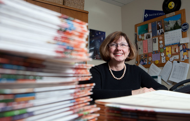 Debra Shaver, dean of admission, sits by stacks of applications to Smith College in Northhampton, Mass.