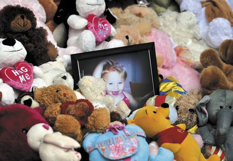 A picture of Ayla Reynolds sits among a shrine of teddy bears on the steps of Waterville City Hall during a vigil for the missing toddler in downtown Waterville on Saturday.