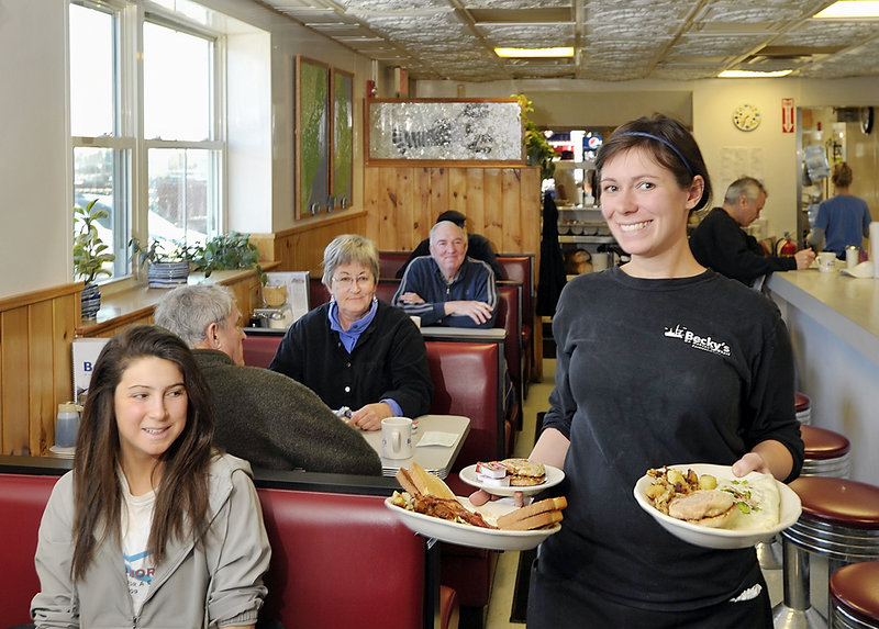 Server Cameron Jordan has her hands full of breakfast dishes, including an omelet for Liana Rubinoff, at left. Becky’s is a classic diner that serves breakfast all day.