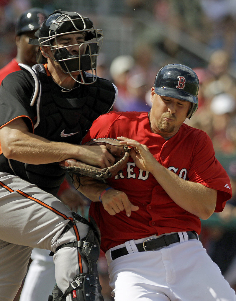 Ryan Lavarnway of the Boston Red Sox, right, is tagged out by Baltimore catcher Taylor Teagarden while trying to score on a Cody Ross double in a 5-4 victory Tuesday.