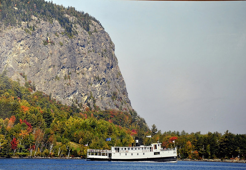 The Katahdin, known as the Kate by residents of the Greenville area, cruises by Mount Kineo on Moosehead Lake during an autumn cruise.