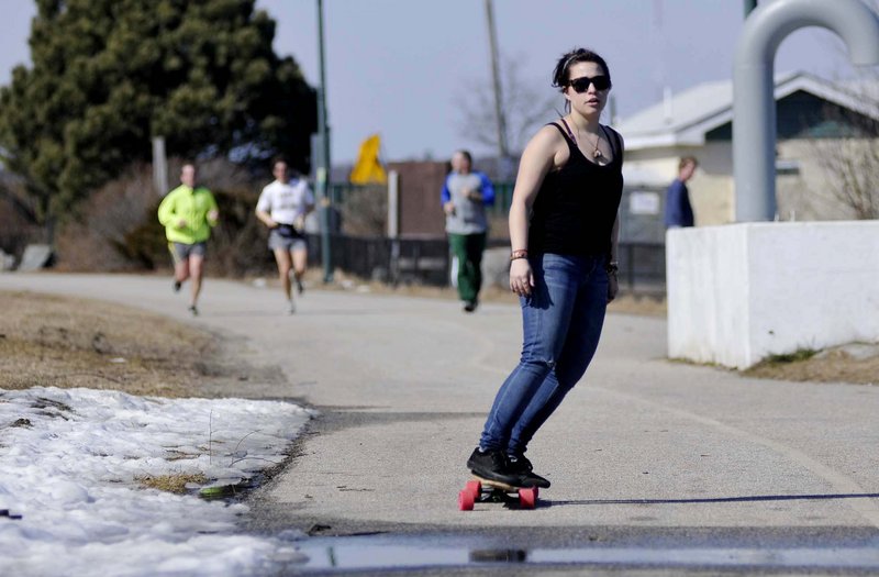 Lauren Collins of Portland rides her board along the Eastern Prom Trail in Portland on Thursday. A student at Maine College of Art with free time between classes, Collins was taking advantage of the unseasonable warmth.