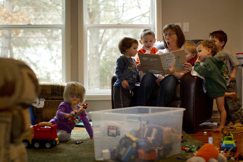 Denise Sjoberg reads books to children last month at the day care she runs at her home in Eagan, Minn. Laid off last year from her job negotiating IT contracts, Sjoberg couldn’t find a new job in her field and decided to open her own business.
