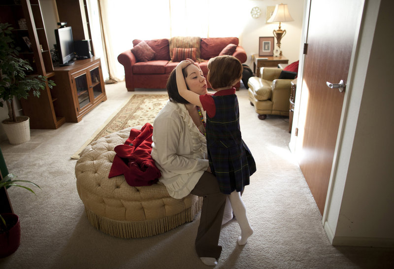 Kate Madonna Hindes hugs her daughter, Ava, before starting her new job in Chaska, Minn., in February.