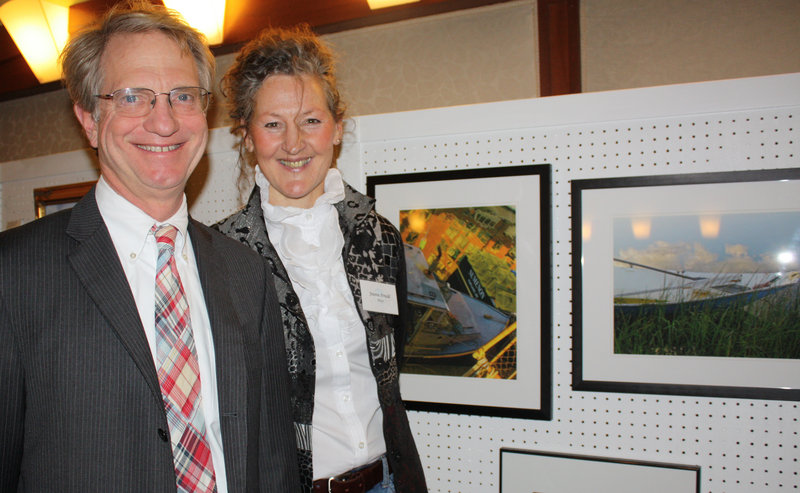 Carl Gercke of HeadInvest and artist Joanne Arnold stand next to Arnold’s two photographs that sold during the party.