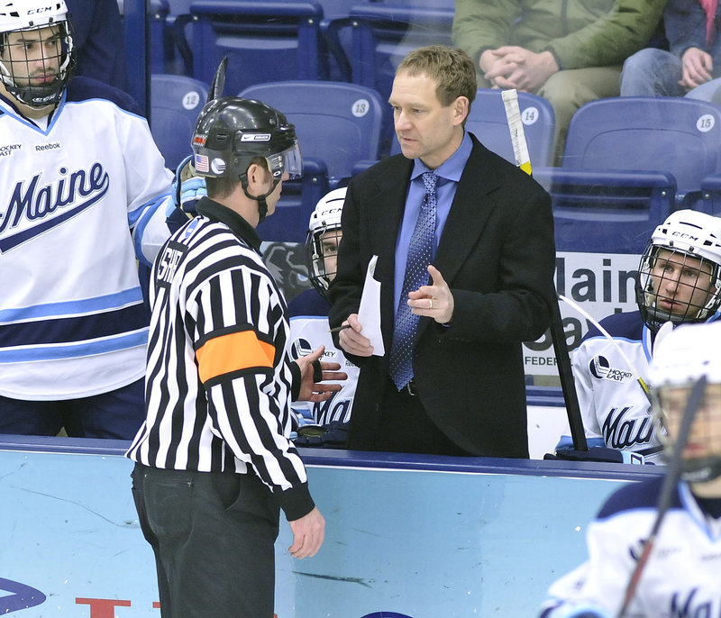 UMaine Coach Tim Whitehead talks with official Kevin Shea during Saturday night’s game. The officials were busy, calling 50 penalties for 184 minutes – both league playoff records.