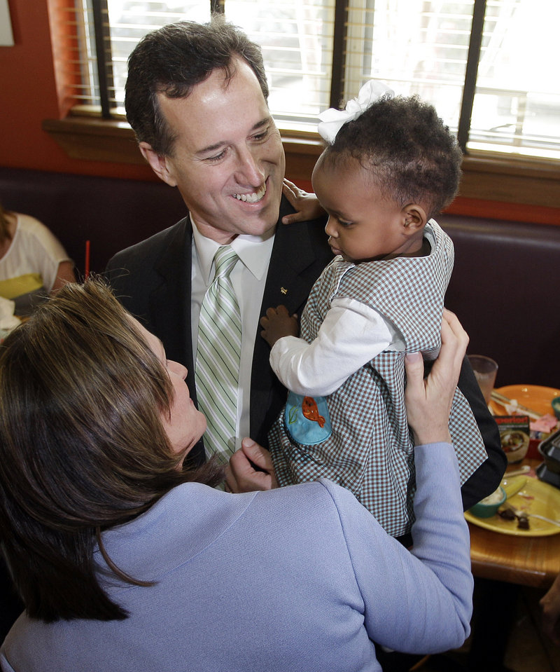 GOP presidential candidate and former Pennsylvania Sen. Rick Santorum and his wife, Karen, visit with 21-month-old Lucy Polsgrove at Sweet Peppers Deli on Sunday in Tupelo, Miss.