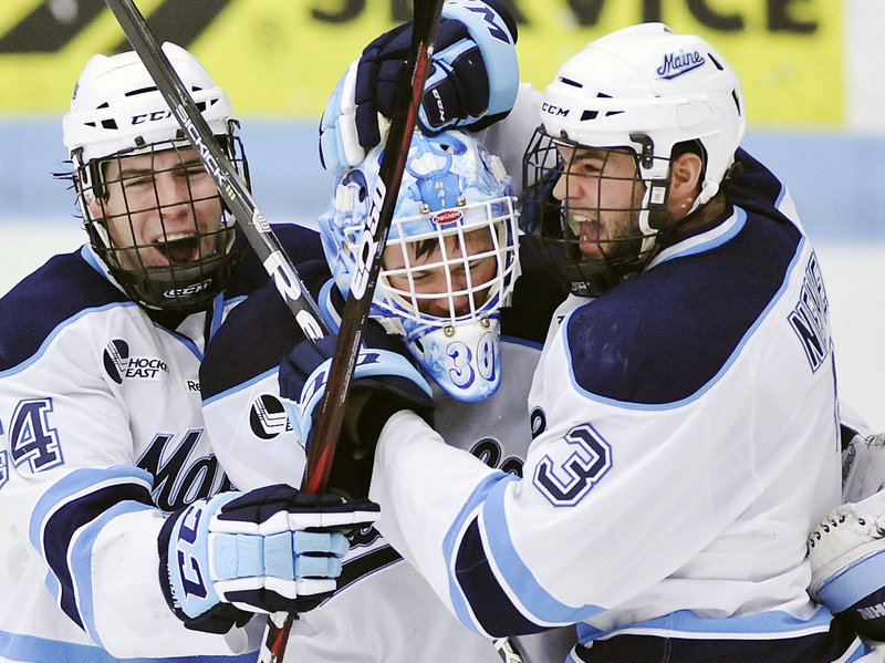 Goalie Dan Sullivan celebrates with Ryan Hegarty, left, and Mark Nemec after Sunday’s 2-1 win over Merrimack in the Hockey East quarterfinals at Alfond Arena. Sullivan made 20 saves as Maine went the distance to win the best-of-three series.