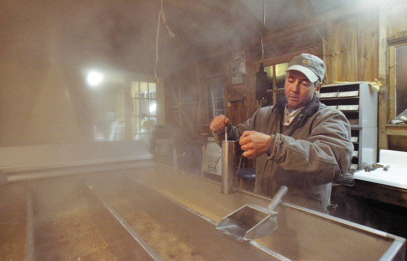 Mark Cooper checks the density of his maple syrup with a hydrometer while boiling sap at his sugar house in Windham earlier this month.