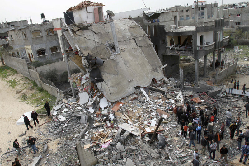 Palestinians inspect the rubble of a building after an Israeli airstrike in Jabaliya on Monday. Prime Minister Benjamin Netanyahu warned Israel is “ready to broaden its operation.”