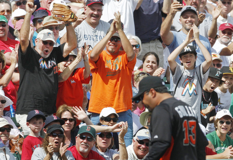 Ozzie Guillen, the new manager of the Miami Marlins, draws a reaction from fans Monday in Fort Myers, Fla., after being ejected for arguing a foul-ball call during Boston’s 5-3 victory in 10 innings.