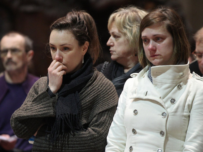 Two teachers from the Sint Lambertus school in Heverlee attend a mass at the Saint-Peters church in Leuven, Belgium, Wednesday, held for the bus crash victims.