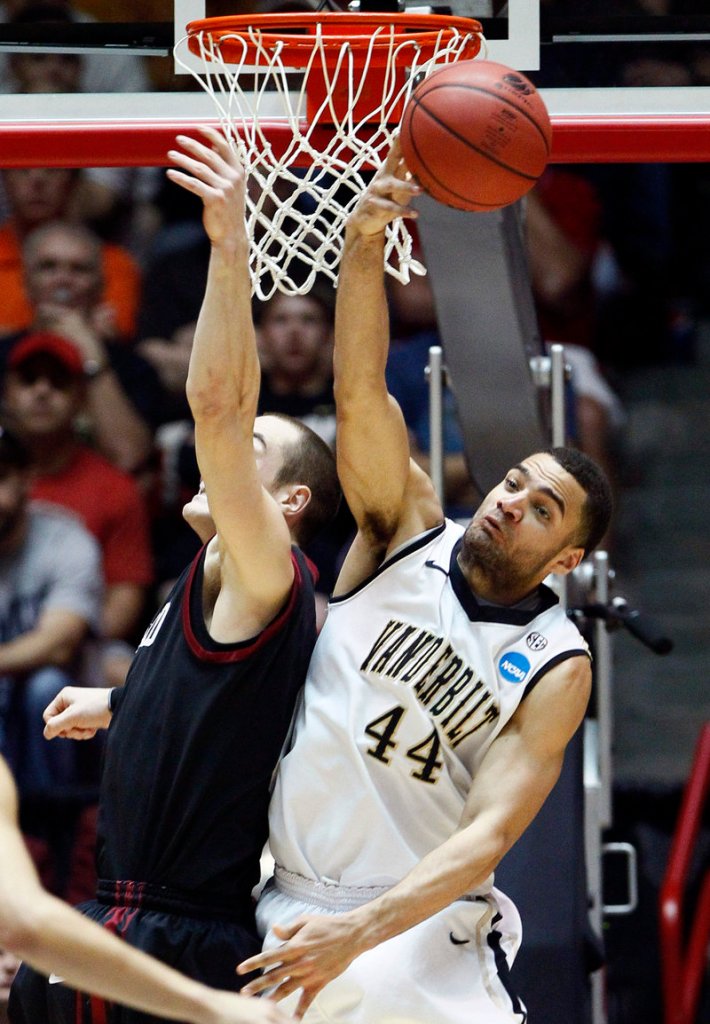 Jeffery Taylor of Vanderbilt knocks away a shot by Laurent Rivard, who finished with 20 points Thursday for Harvard. Vanderbilt advanced to meet Wisconsin after a 79-70 victory.