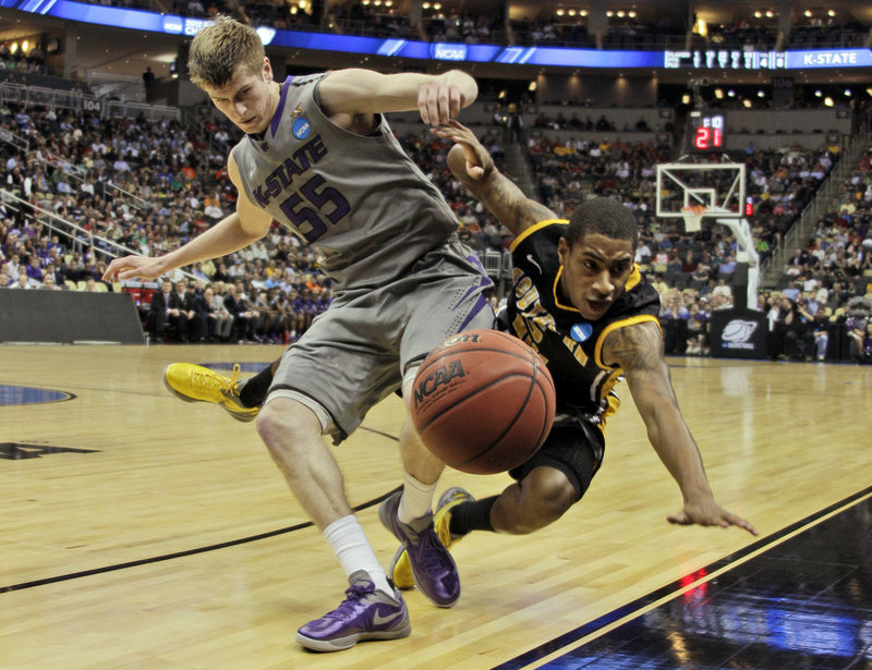 The ball heads out of bounds Thursday as Will Spradling of Kansas State, left, collides with Neil Watson of Southern Mississippi during Kansas State’s 70-64 victory in the first round of the NCAA tournament.