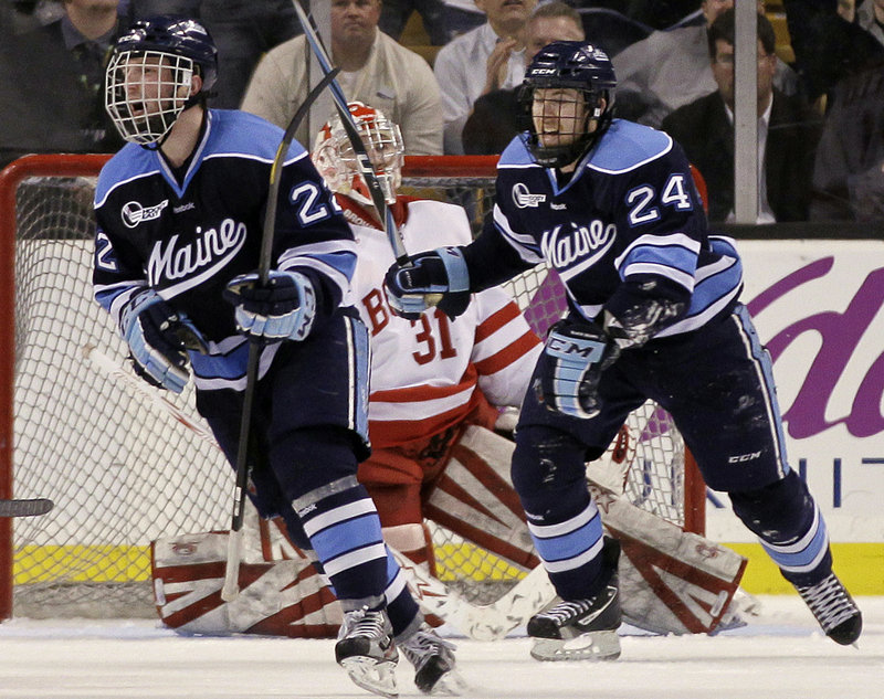 Stu Higgins, left, and Mark Anthoine of the University of Maine celebrate a goal by teammate Will O’Neill as Boston University goaltender Kieran Millan reacts in the second period Friday night. The Black Bears won, 5-3.