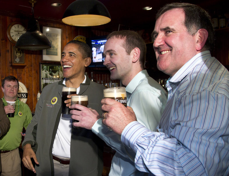 President Obama drinks a Guinness with his cousin Henry Healy, center, and the owner of the pub in Moneygall, Ireland, Ollie Hayes.