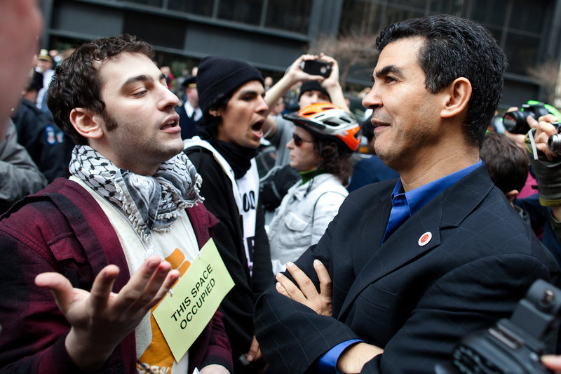 New York City Councilman Ydanis Rodriguez listens to an Occupy Wall Street demonstrator in Zuccotti Park after a march to celebrate the protest’s sixth month Saturday. A couple hundred people attended.