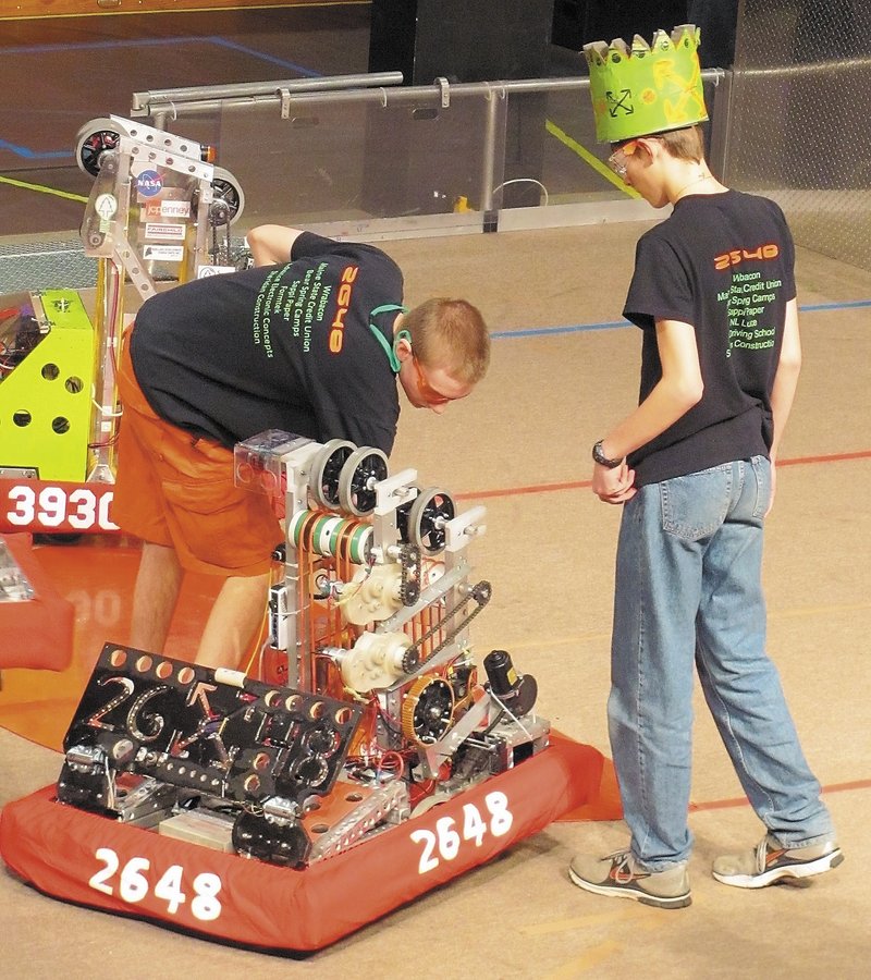 Infinite Loop Robotics Team members Ian Bernier, left, and Bradley Bickford handle their competition robot during a recent robotics event.