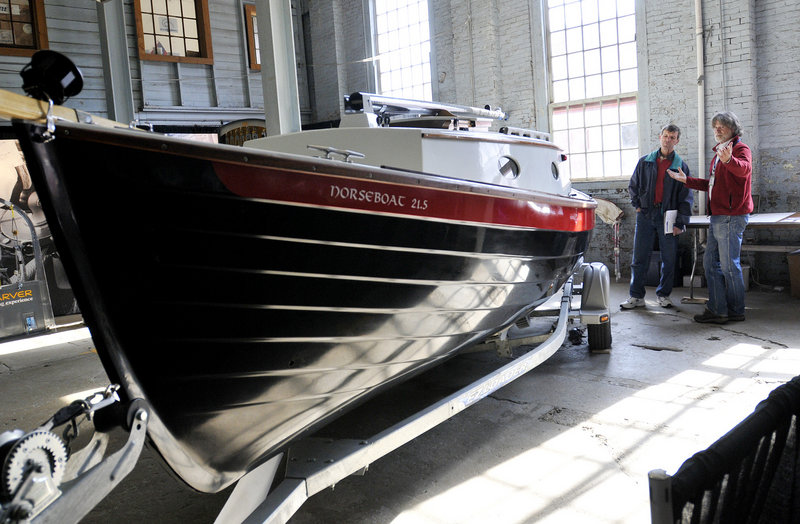 Kevin Jeffrey, right, shows off a NorseBoat 21.5 Sunday to Rich Kania of Brunswick during the Maine Boatbuilders Show at the Portland Company Complex on Sunday. Exhibitors reported a definite uptick in business at the show after several years of slow sales.