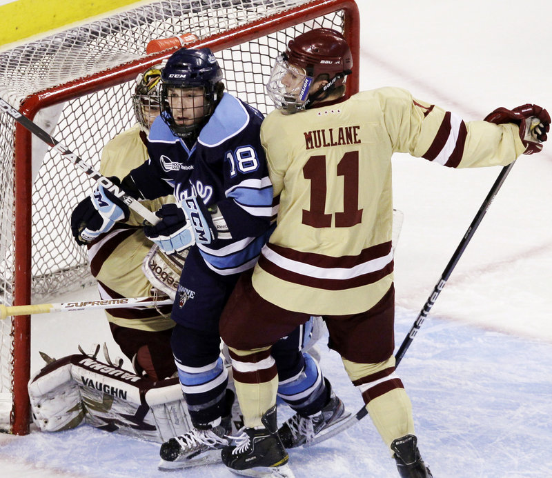 Jon Swavely of Maine is sandwiched between Boston College goaltender Parker Milner, left, and Pat Mullane in the first period of the Hockey East final Saturday.