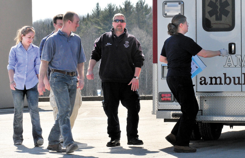 Three people at left, including customer Becca Mattingly, are led to an ambulance to be examined after they were covered with a fire-suppressant powder that was released and covered people, vehicles and the road at the Irving Circle K store in Skowhegan on Sunday. “I was shocked and scared at first but I’m all right,” Mattingly said later.