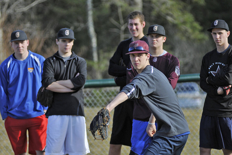 Will McAdoo of Greely works on a pickoff move as the pitchers look on during the Rangers’ first practice of the season Monday at Cumberland. Due to the warm temperature, many teams were able to leave their gyms and work outside, a rare occurrence in Maine.