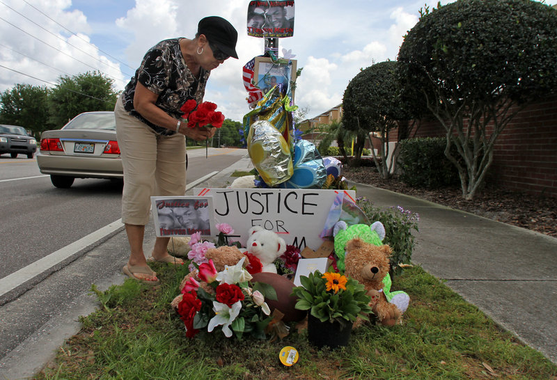Claudette Hutchinson of Sanford adds to a memorial Tuesday for teenager Trayvon Martin outside the Retreat at Twin Lakes, where Trayvon was shot and killed.