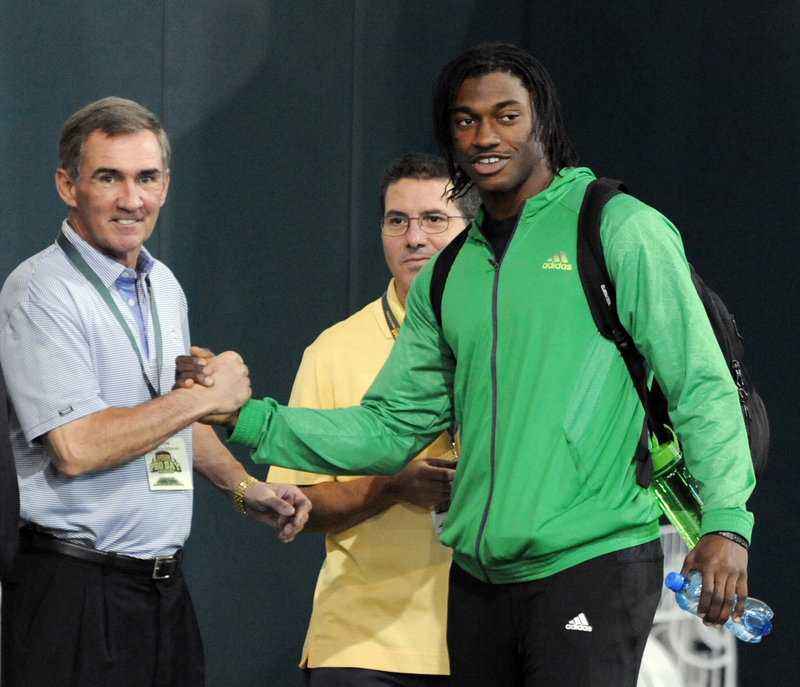 Redskins Coach Mike Shanahan shakes hands with Heisman winner Robert Griffin III during Baylor’s NFL pro day Wednesday. The Redskins expect to draft Griffin next month.