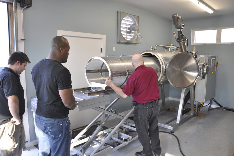 Jeff Edwards, right, explains to JoJo Oliphant, manager of Direct Cremation of Maine in Searsport, how to operate a cremation machine that uses a chemical process to dissolve a body in 12 hours.