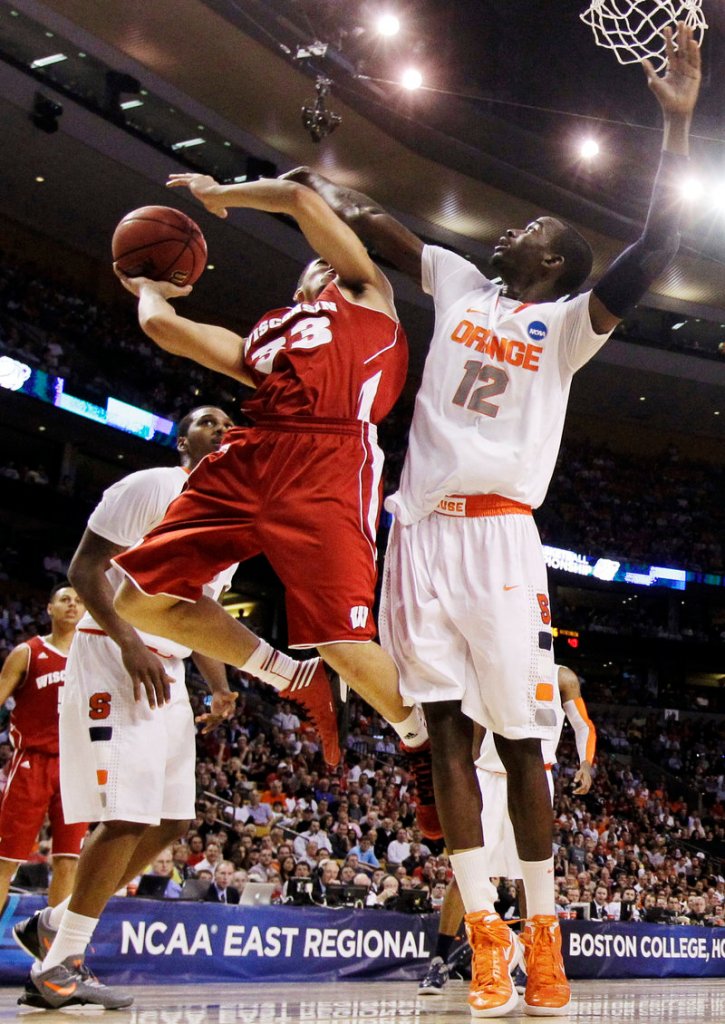 Rob Wilson of Wisconsin attempts to get off a shot while defended by Baye Keita of Syracuse during the second half of Syracuse’s 64-63 victory Thursday night.