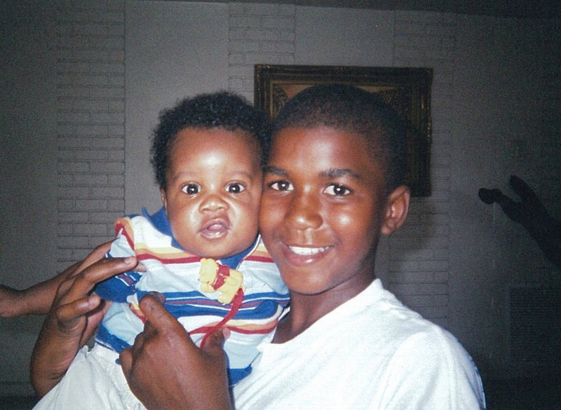In a photo provided by the Martin family, Trayvon Martin holds an unidentified baby. A portrait has emerged of Martin as a laid-back young man who loved sports.