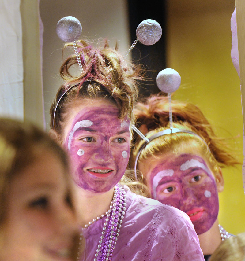 Amelia Lorrey, left, and Olivia Stites, students at the Shapleigh School, await their team’s turn onstage for their “Odyssey Angels” performance at the Odyssey of the Mind tournament.