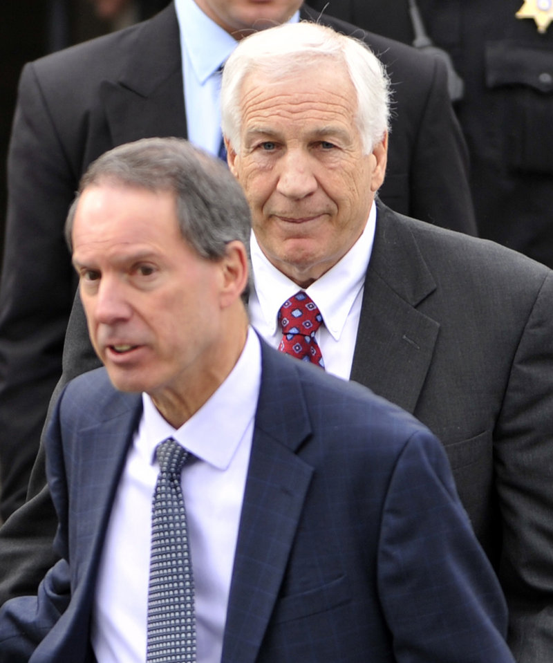 Jerry Sandusky, back, a former Penn State assistant football coach charged with sexually abusing boys, and his attorney, Joseph Amendola, front, leave the Centre County Courthouse, in Bellefonte, Pa., after a hearing in February.