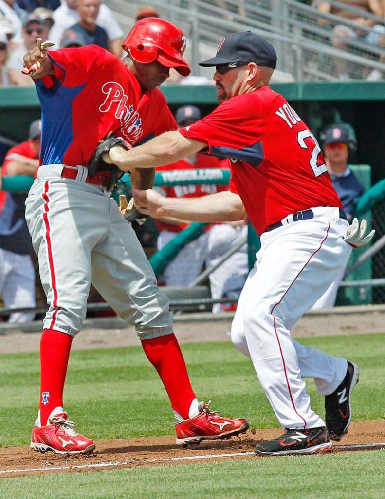 Kevin Youkilis of the Boston Red Sox tags out Juan Pierre of the Philadelphia Phillies to end a rundown Saturday during the Phillies’ 10-5 victory at Fort Myers, Fla. Also Saturday, the Red Sox beat the Miami Marlins, 4-1.