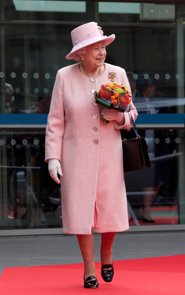 Britain’s Queen Elizabeth II dropped in on a couple’s wedding while visiting Manchester Town Hall on Friday.