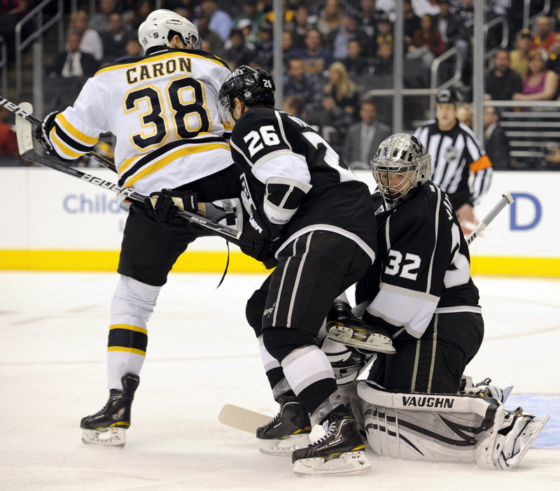 Jordan Caron of the Bruins positions himself in front of Kings goalie Jonathan Quick and defenseman Slava Voynov in Saturday’s game at Los Angeles. The Bruins won, 4-2.
