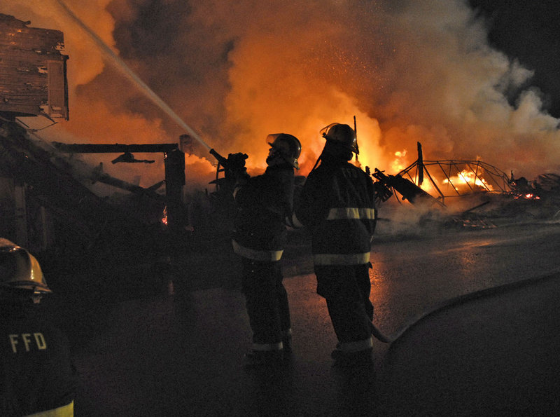 Firefighters work to put down a blaze that destroyed five buildings in downtown Fort Kent early Sunday. Nadeau’s House of Furniture occupied three of the buildings, Acadia Home Care occupied a fourth, and the fifth was vacant.