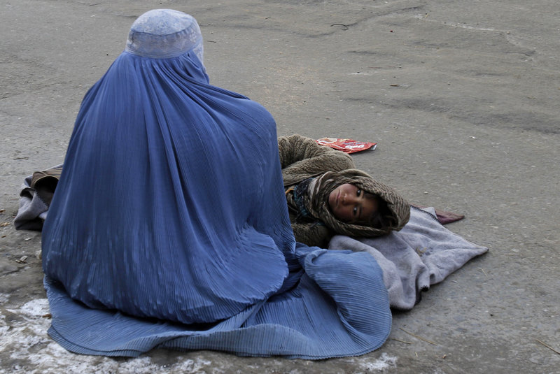 An Afghan woman begs with her child in Kabul. Human Rights Watch reports that Afghan women can be imprisoned for being raped or escaping domestic abuse.